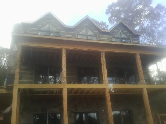 Dormers and porch framing on a large log home under construction in Greenfield