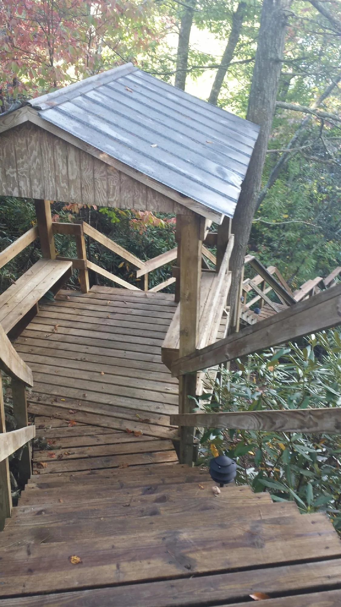 Metal roofed shelter over wooden steps on a wooded walkway — Skylight Repair & Installation work by our crew in Greenfield